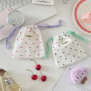 Close-up of drawstring storage pouches with heart patterns in white, red and black colors
