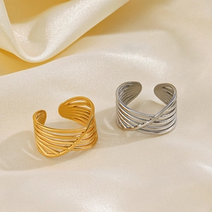 Minimalist crisscross layered open rings in gold and silver finish on satin fabric