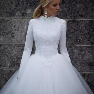 Elegant white lace long sleeve wedding dress with a high neck and voluminous tulle skirt
