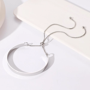 Detail van een verstelbare zilveren metalen armband met boxketting en glad oppervlak