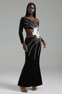 Détail d'une robe de soirée asymétrique en velours noir avec perles et fleur 3D