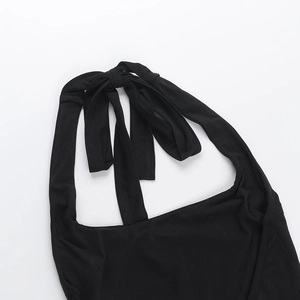 Detail of black halter neckline with knotted tie closure on slim fit knitted jumpsuit