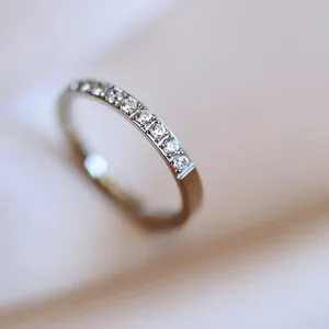 Macro shot of minimalist titanium steel ring featuring sparkling half-circle set crystals