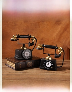 Close-up of vintage black and gold dial telephone models on retro books and wood