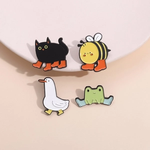 Set of four cute cartoon animal enamel pins wearing colorful boots on a beige stand