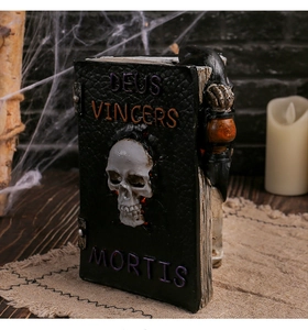 Gothic resin book with skull relief and skeletal hand, perfect for Halloween party decor