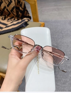 Detailed view of pink gradient lenses with transparent frames and metallic bridge detail