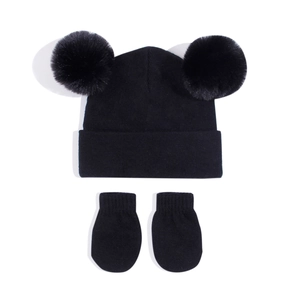 Detail view of baby black knit beanie with dual faux fur pom-poms and matching mittens