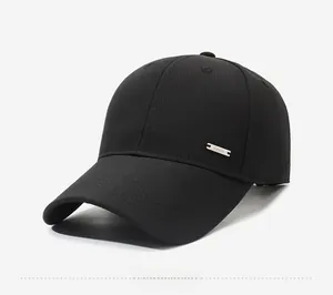 Detail view of the silver metal plate logo on a textured black baseball cap for men