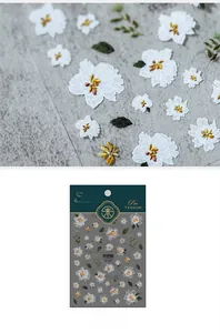Macro detail of 3D embossed floral nail stickers featuring white petals and golden stamens
