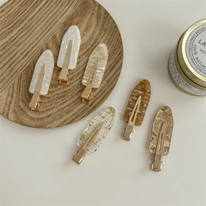 Set of 6 minimalist non-marking French resin hair clips on a wooden tray background