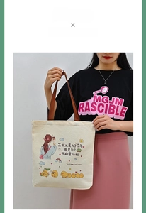 Detail of canvas tote bag featuring cute cartoon girl illustration and sturdy brown handles