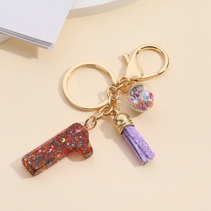 Detail of red glitter number 1 keychain with purple tassel and star filled crystal ball