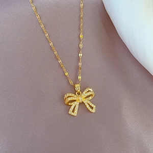 Detailed close-up of a gold-plated titanium butterfly pendant with sparkling zircons