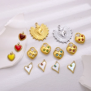 Assorted gold and silver stainless steel heart pendants on white textured stone background