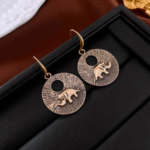 Gros plan détaillé des boucles d'oreilles éléphant dorées vintage au motif ethnique