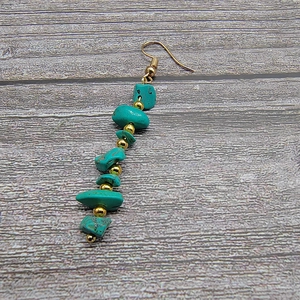 Detail of bohemian long tassel earrings with natural turquoise and gold beads