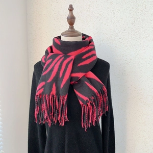 Close-up of red and black zebra stripe scarf with fringe details for winter fashion