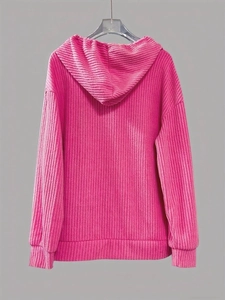 Detailed texture of pink ribbed corduroy hoodie with adjustable drawstring and cuffed sleeves