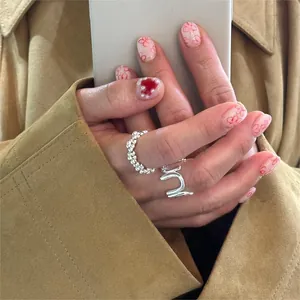 Detailed close-up of a minimalist S925 silver U-shaped ring set worn on a hand