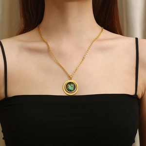 Elegant gold titanium steel necklace featuring a green resin heart pendant on model