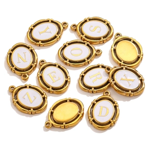 Macro detail of oval gold-plated charms with white enamel and golden A-Z letters