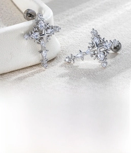 Macro detail of silver star-cross earring showing dimensions and zircon inlay textures
