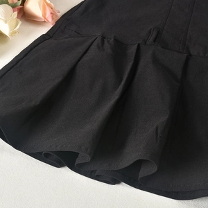 Gros plan détaillé sur la texture du tissu plissé noir d'une robe d'été sexy