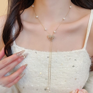 Close-up of 18k gold plated tassel necklace with pearl flower and shimmering cubic zirconia