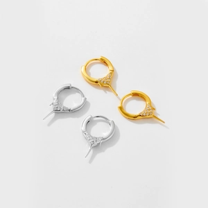 Detail of silver and gold huggie hoop earrings with sparkling crystal triangle charms