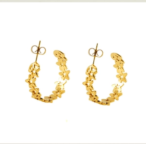 Detailed close-up of golden hollowed-out star hoop earrings with butterfly backings