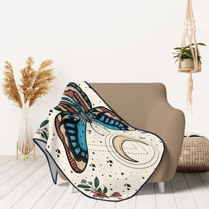Detail of bohemian flannel blanket with moon and butterfly prints on a sofa