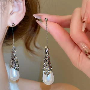 Macro detail of elegant 18k gold plated silver needle pearl drop earrings with mesh decor