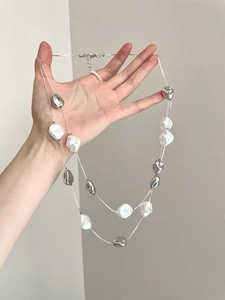 Detail of double-layer silver chain with irregular metallic beads and faux white pearls