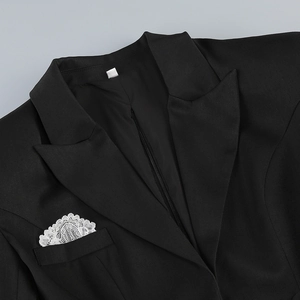 Detail shot of black blazer featuring delicate white lace pocket square decoration