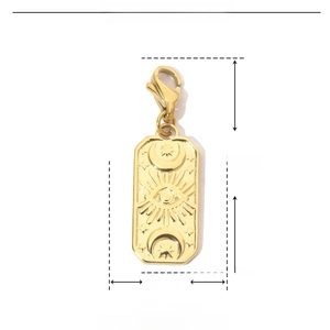 Detail view of gold celestial pendant with moon and sun patterns in stainless steel