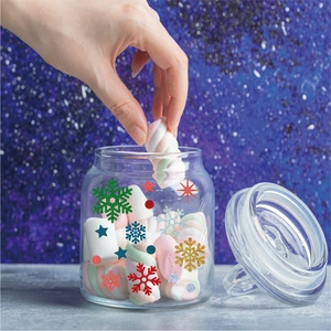 Detail of Christmas snowflake stickers on a glass jar filled with colorful marshmallows