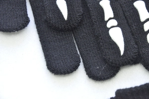 Detailed close-up showing the knit texture and luminous skeleton bone print on the glove