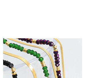 Dettaglio di una catena a serpente piatta dorata e cavigliere con perline colorate