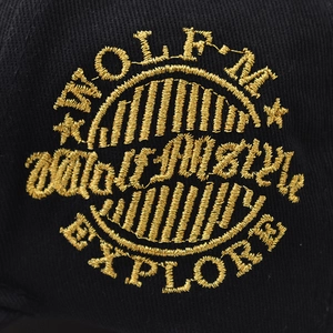 Close-up of gold thread embroidery with stars and text on a black cotton baseball cap