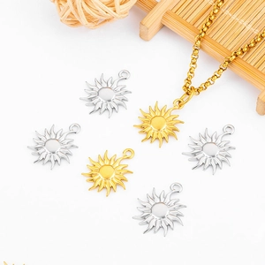 Minimalist sun pendant necklace in gold and silver finish on a natural bamboo mat