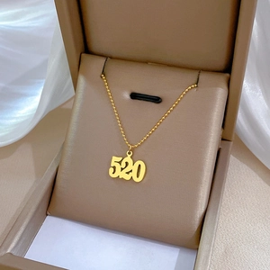 Gold-plated 520 numeric pendant necklace in a jewelry box on white silk fabric