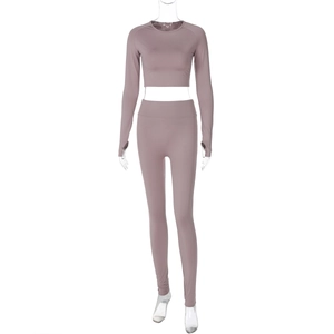 Detail view of pink long sleeve crop top and high waist yoga pants in knit texture