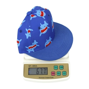 Detailed weight display of kids navy blue shark snapback hat on a digital scale