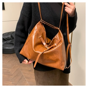 Detail view of the brown leather tote bag showing rich texture and vintage slouchy fit