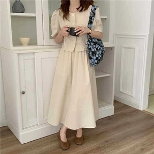 Close-up of beige two-piece cotton linen dress set featuring short-sleeved buttoned top