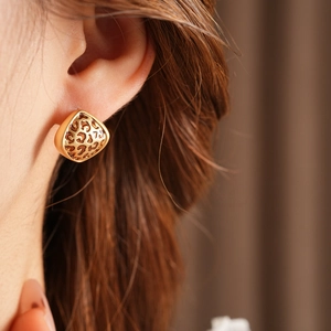 Gros plan de boucles d'oreilles triangulaires dorées à motif léopard portées par un mannequin