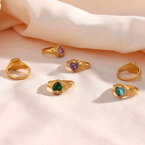 Macro shot of 18K gold plated heart zircon rings on pink silk background texture