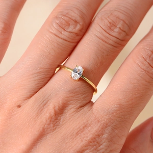 Minimalist gold sterling silver ring with oval clear zircon stone on model hand