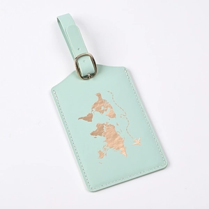 Close-up of mint green PU leather luggage tag with gold foil world map and metal buckle